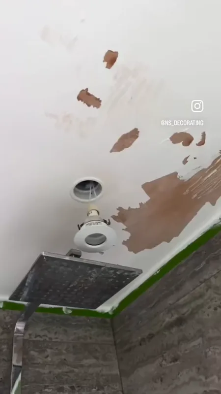 The loose paint scraped back over the shower, leaving bare patches to make good