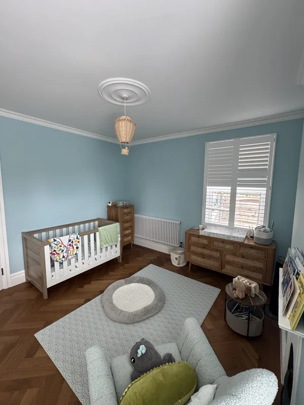 Nursery: blue walls, white woodwork and shutters