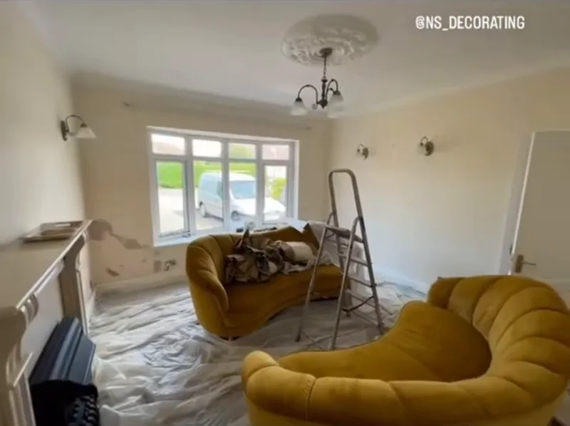 The living room towards the window, sheeted up for the repairs, then finished — during
