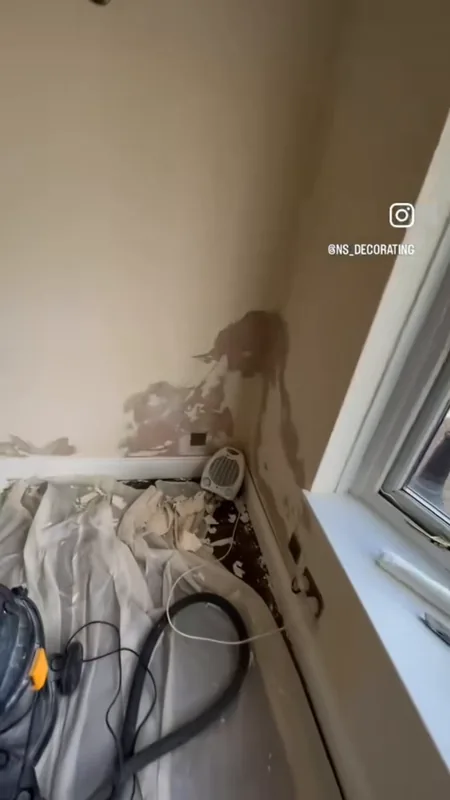 The wall by the window, repaired and painted — during