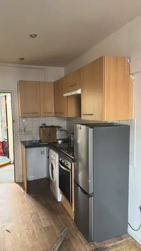 The kitchen cabinets, painted grey instead of replaced — before