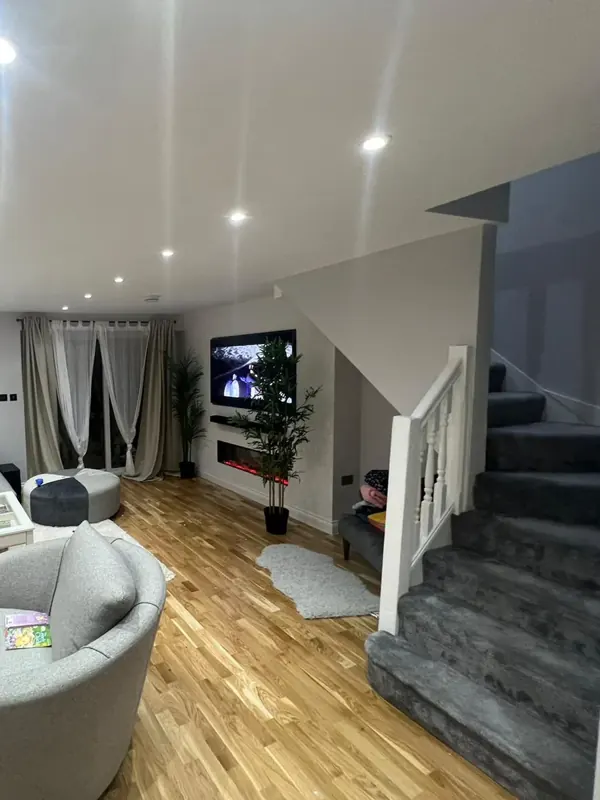 Living room: new oak flooring, staircase, lighting and media wall — after