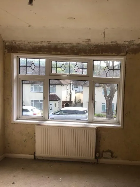 Main front bedroom: same leaded window, now replastered, carpeted and decorated — before