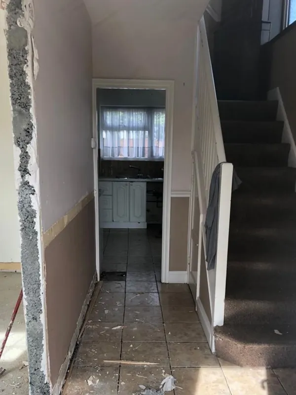 Hallway from the front door: new marble-effect tiles, staircase and doors — before