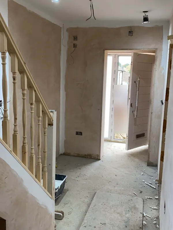 Hallway: bare plaster and subfloor to marble-effect tiles — during
