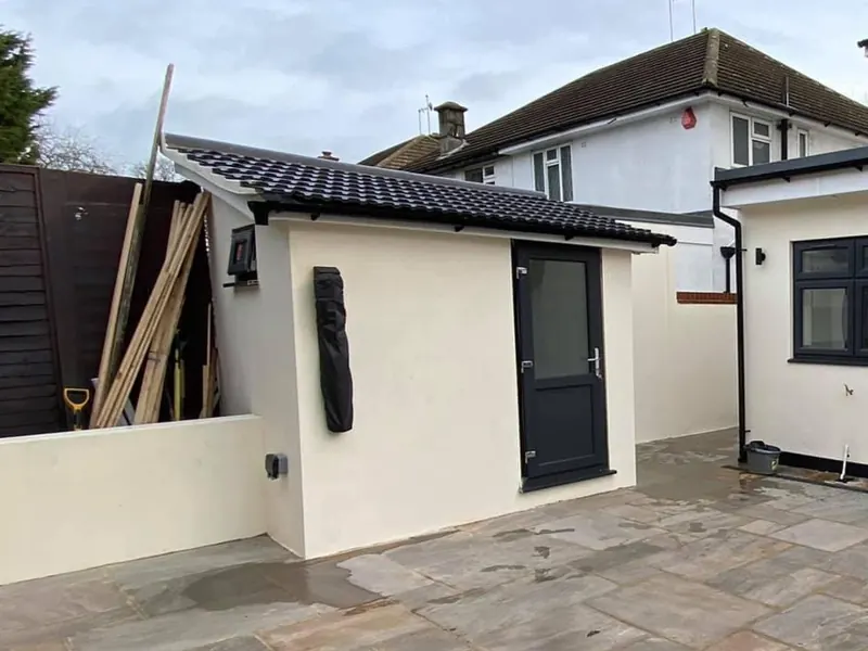 The small shed: rendered and finished with a new door — after