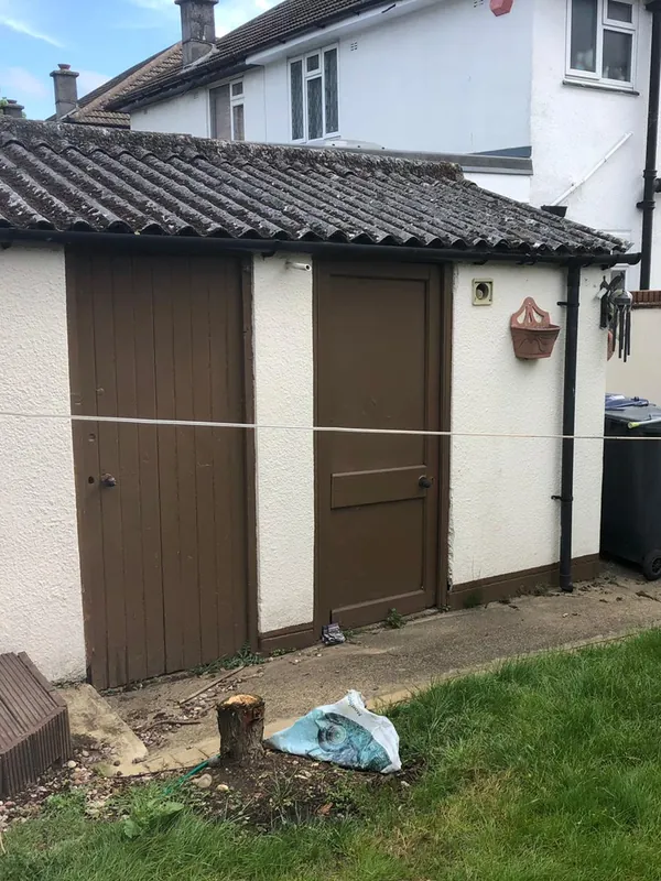 The small shed: rendered and finished with a new door — before