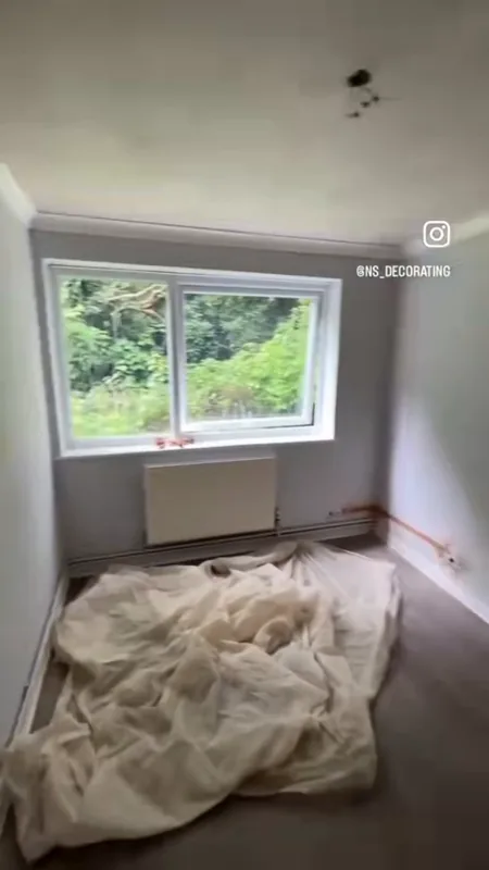 A bedroom, the walls filled, then painted — during