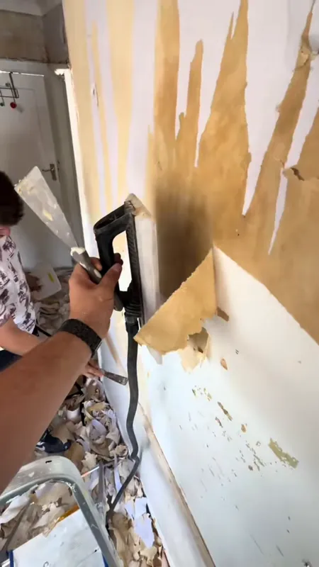Stripping the old wallpaper in the hallway