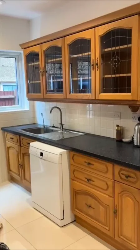 The sink run before, with its pine units and leaded-glass wall cupboards