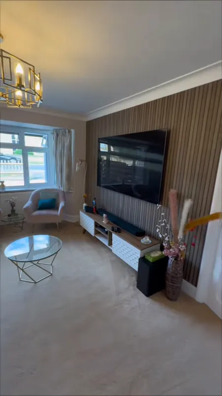 The living room, TV wall and door — after