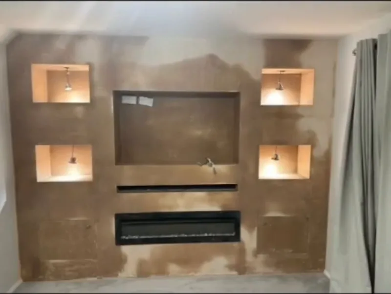 The new media wall, freshly skimmed with the niche lights on, then finished — during