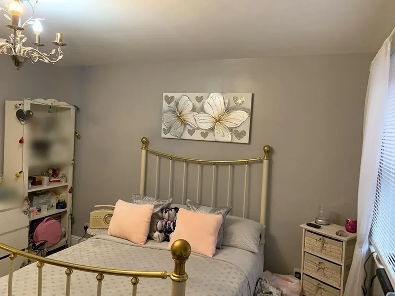 A bedroom: floral wallpaper off, walls painted grey — after