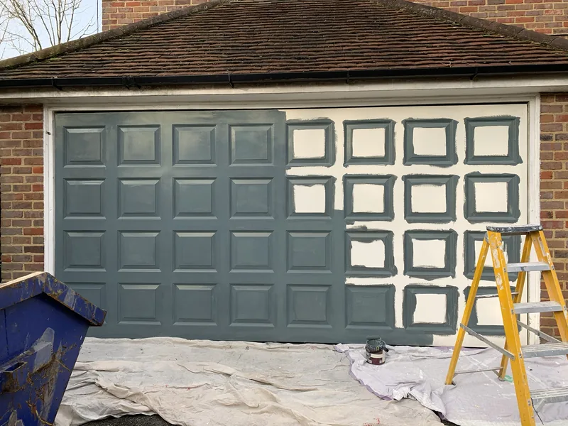 The garage door halfway through, white to dark blue-grey