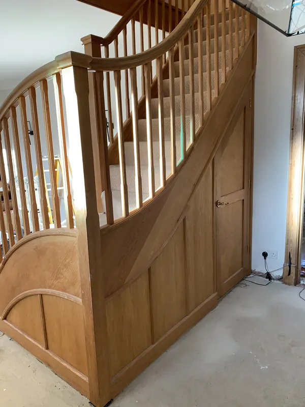 The oak staircase and the panelling underneath, painted grey — before