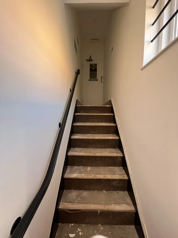 Up to the fire exit door: patchy walls made good and repainted — after