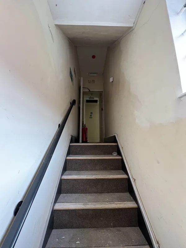 Up to the fire exit door: patchy walls made good and repainted — before
