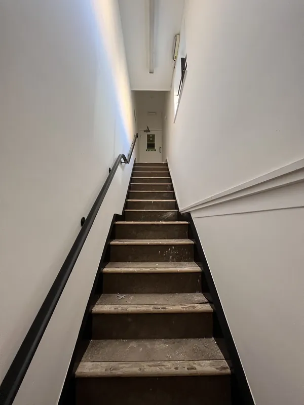 Stairwell from the bottom: walls, ceiling and woodwork redecorated — after