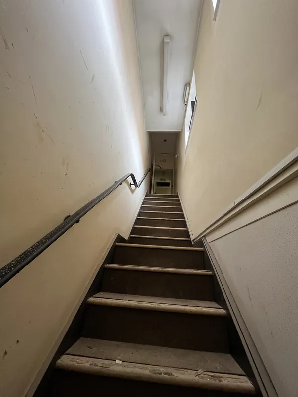 Stairwell from the bottom: walls, ceiling and woodwork redecorated — before