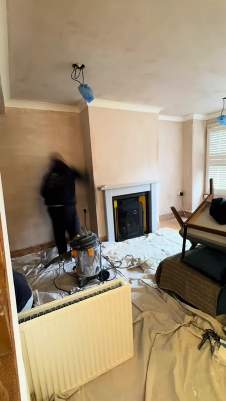 The living room, from bare plaster to a deep blue-green — before