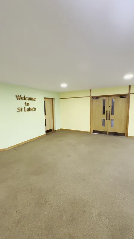 The main hall: warm yellow walls and a lime green feature wall around the lettering — after