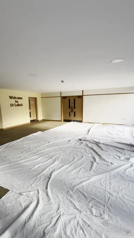 The main hall: warm yellow walls and a lime green feature wall around the lettering — before