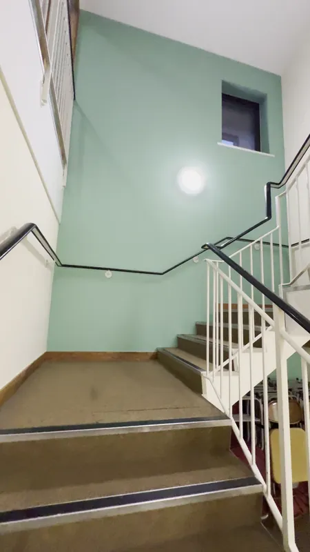 The staircase: walls and ceiling repainted, green feature wall refreshed — after