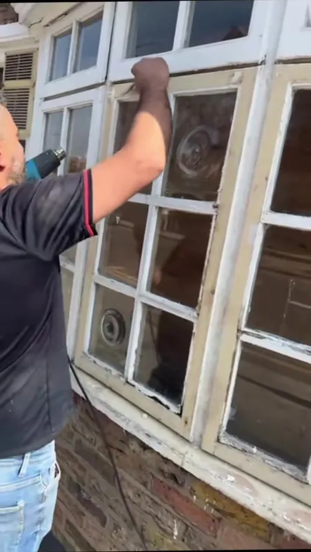 Stripping the old paint off the shopfront windows