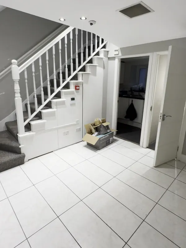 Stair hall: tiles replaced with wood-effect flooring and the walls repainted — before