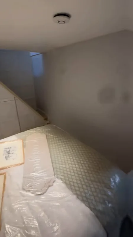 The bed covered and the pictures taken down