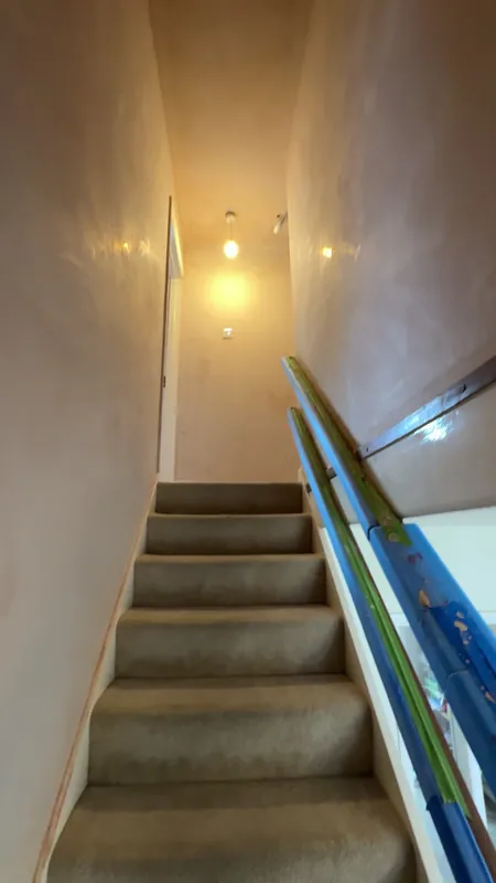 The stairwell: bare plaster, mist coated, then painted — before
